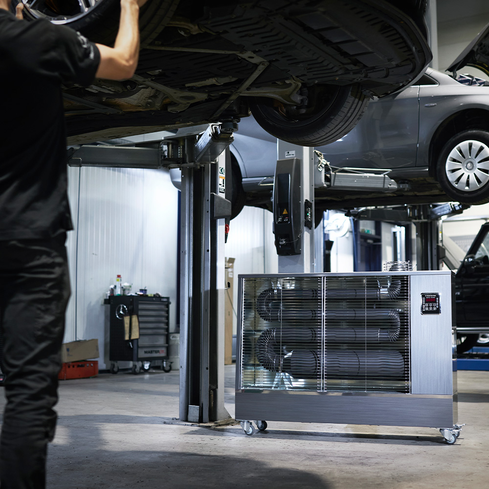 Toyotomi Europe infrared heater heating a car mechanic working on a car