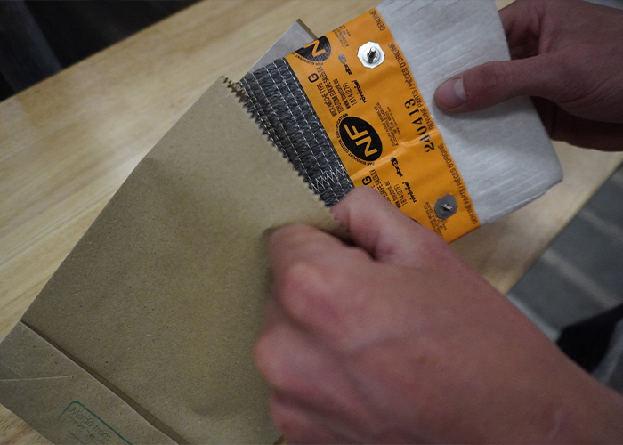 Se está utilizando embalaje de papel de hierba para empaquetar una mecha de fieltro de fibra de vidrio de carbono de Toyotomi Europe, mostrando un embalaje más ecológico.