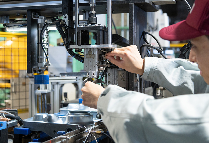 Línea de máquinas de Toyotomi Japón para estufas de parafina siendo ajustada por un empleado de Toyotomi Co. LTD. 