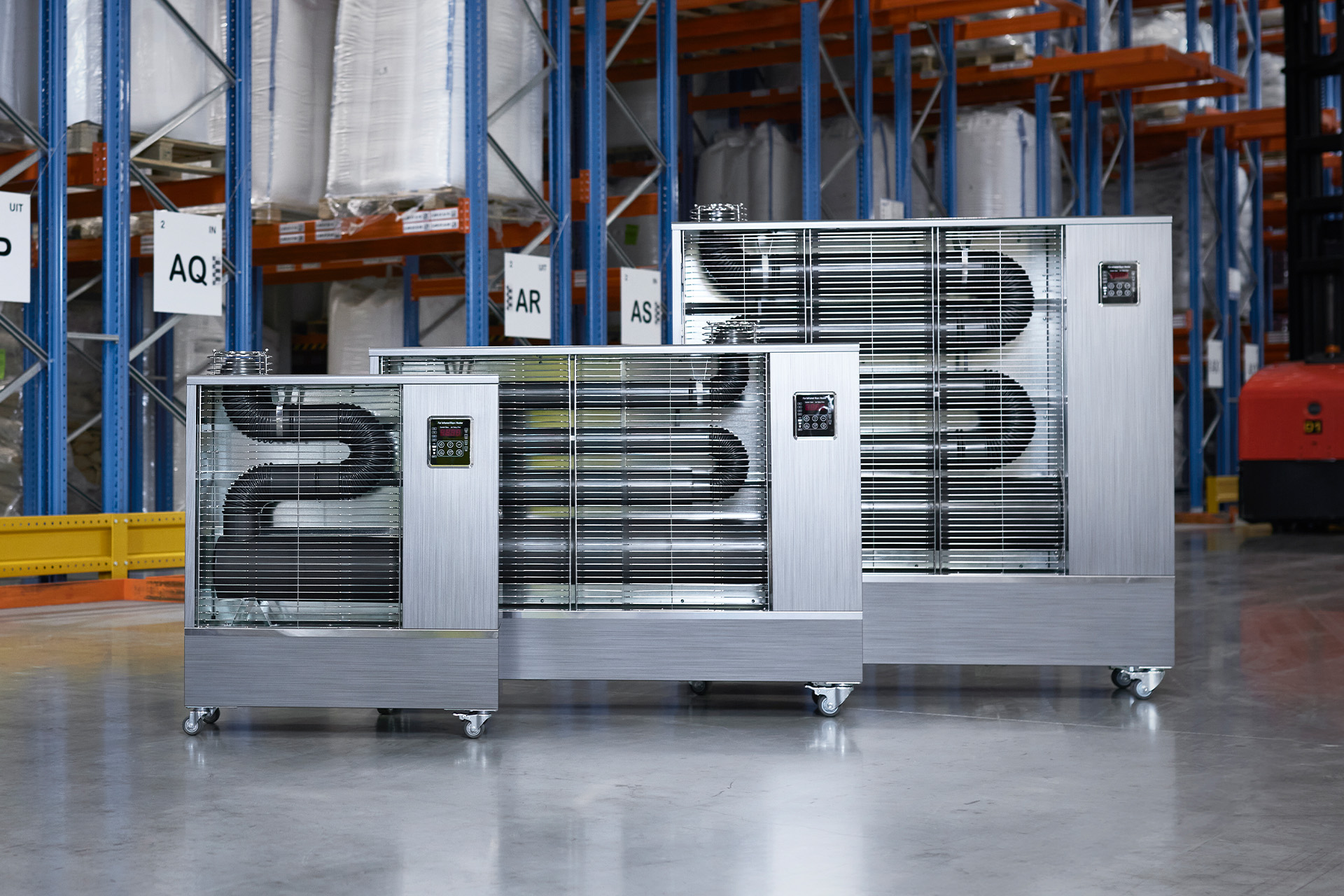 Toyotomi Europe new range of Infrared heaters standing in the middle of a huge warehouse.