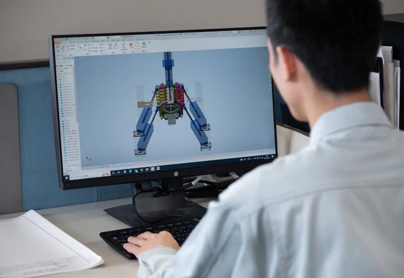 Empleado de Toyotomi Japón trabajando en el diseño de un nuevo componente interno para un calentador portátil de queroseno