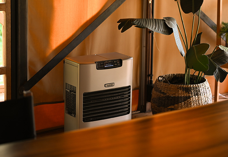 Aquecedor de infravermelhos Toyotomi TIB-16 a aquecer um mecânico numa oficina de automóveis que está a trabalhar num carro.