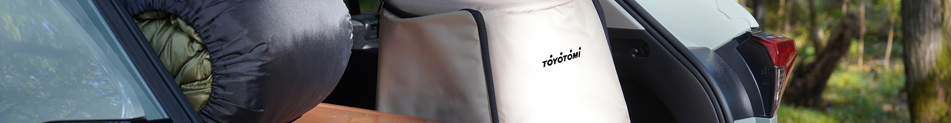 Toyotomi outdoor paraffin heater carrying bag in the back of a car being unloaded for outdoor heating