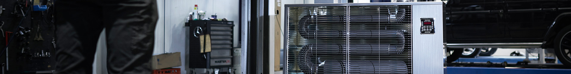 Toyotomi Infrared heater in an auto garage heating up the place with infrared radiation and a mechanic