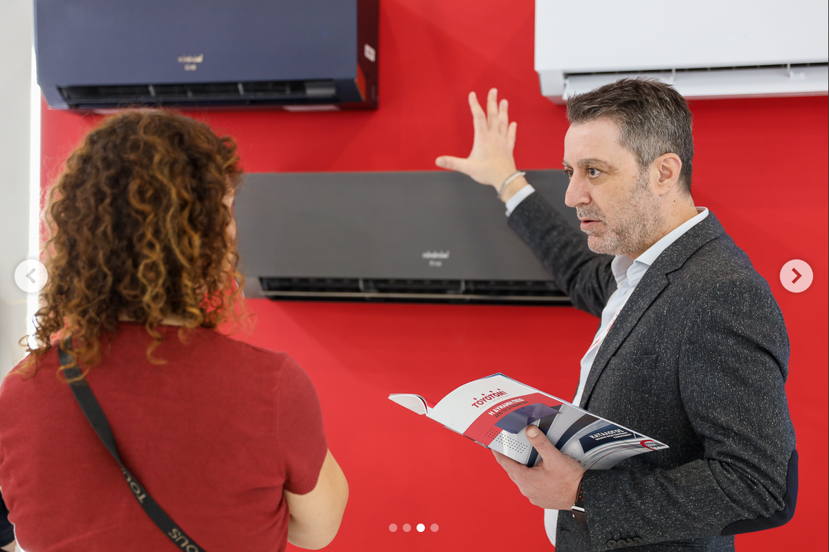 Toyotomi Europe Employee at an air conditioner fair explaining Toyotomi air conditioners to potential dealers