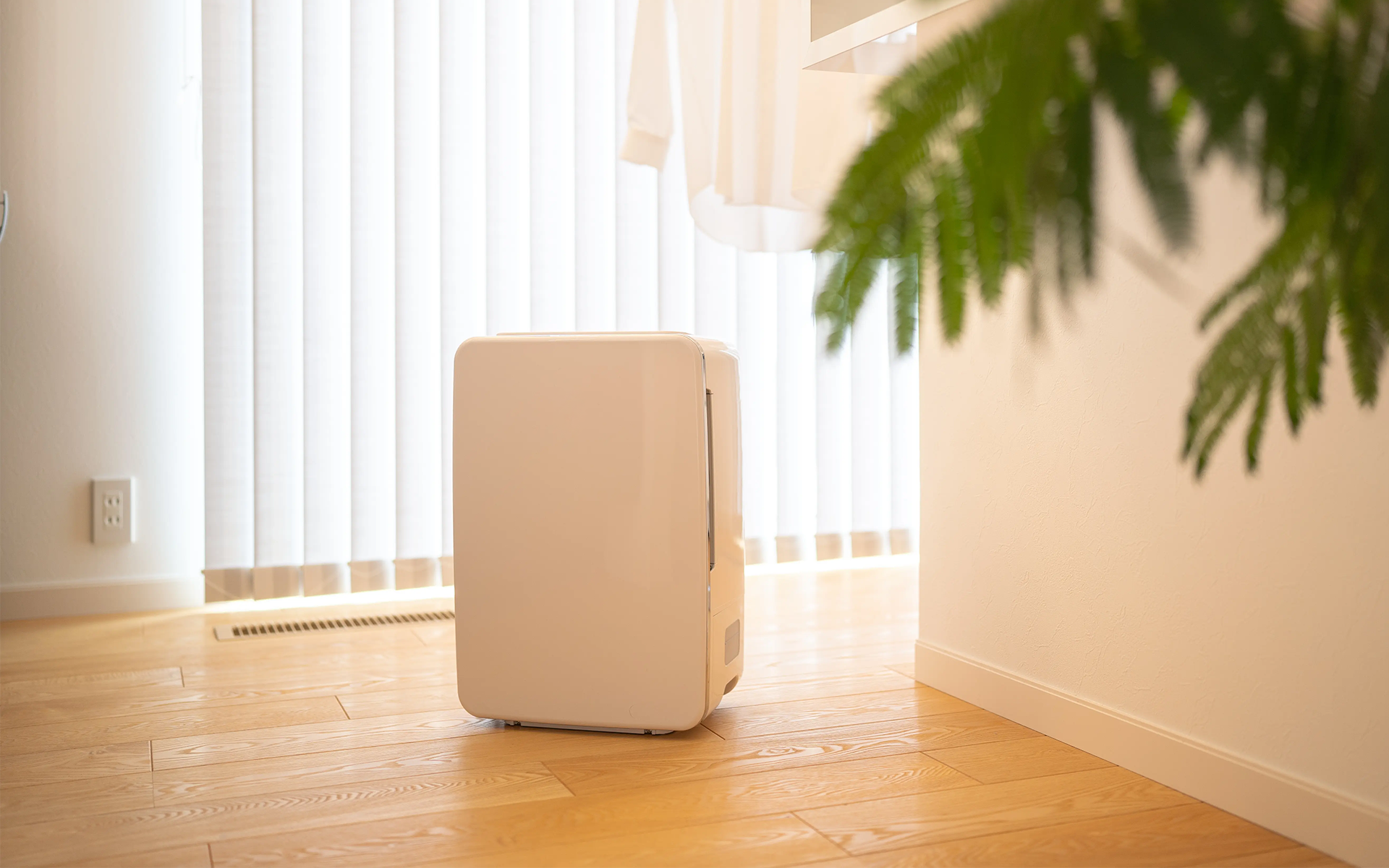 Kompakt bærbar aircondition i et hyggeligt opholdsrum med trægulv.