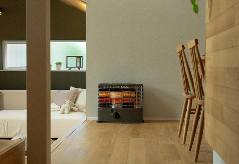 Toyotomi portable paraffin wick heater in a modern wooden living room representing sustainable heaters