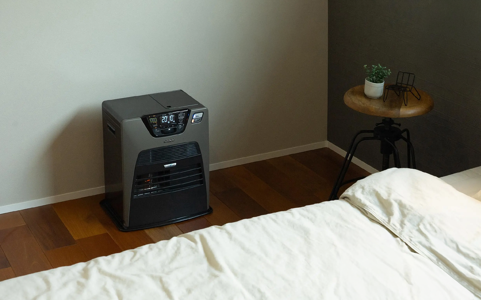 Nærbillede af en moderne Toyotomi ovn sat op i et hyggeligt soveværelseshjørne for varme og komfort.