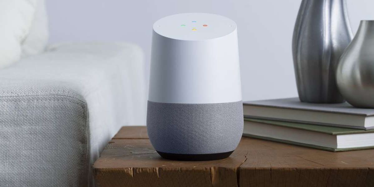 Modern smart speaker on wooden table with books and vases.